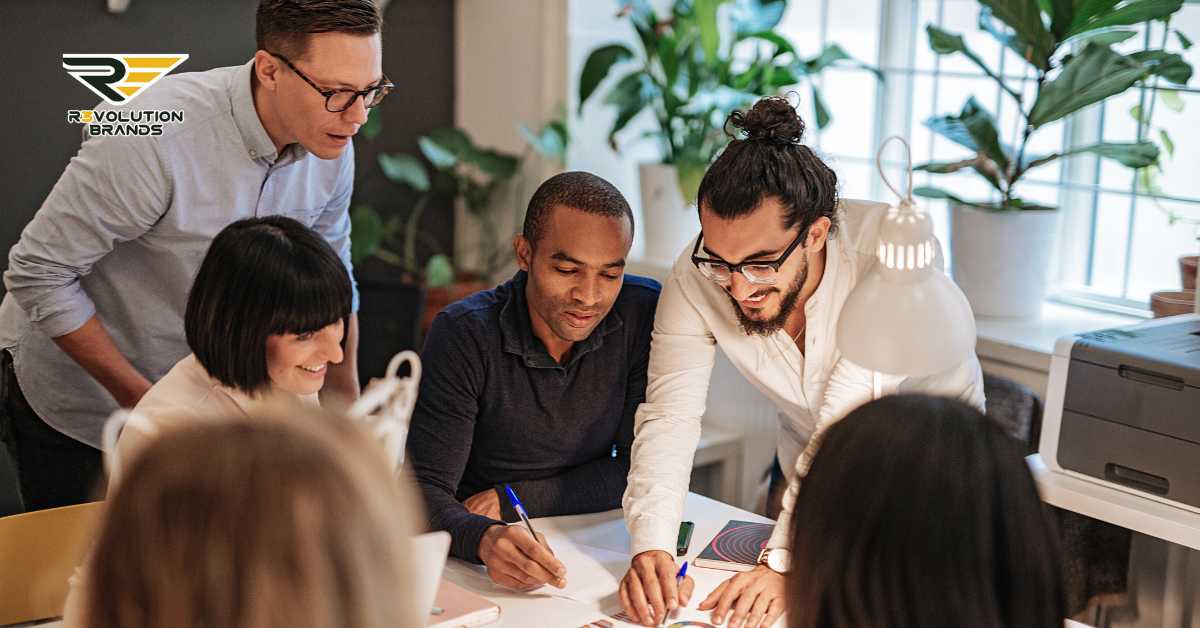 Diverse team of R3volution Brands professionals collaborating around a table, focusing on resilient strategies to adapt to economic challenges in the franchise sector.