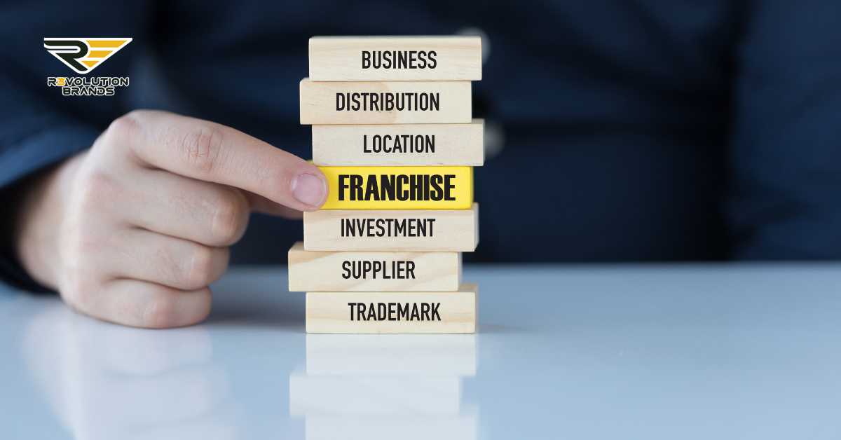 Close-up of a professional hand strategically placing a 'FRANCHISE' block on a stack of wooden blocks labeled with key business elements like Business, Location, and Investment, symbolizing R3volution Brands' structured approach to franchising.